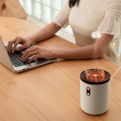 Person using a laptop with a small humidifier on a wooden desk