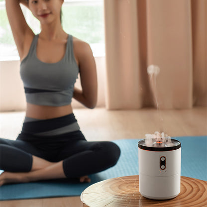 Woman in workout attire sitting on a yoga mat with a small humidifier on a table in front of her.